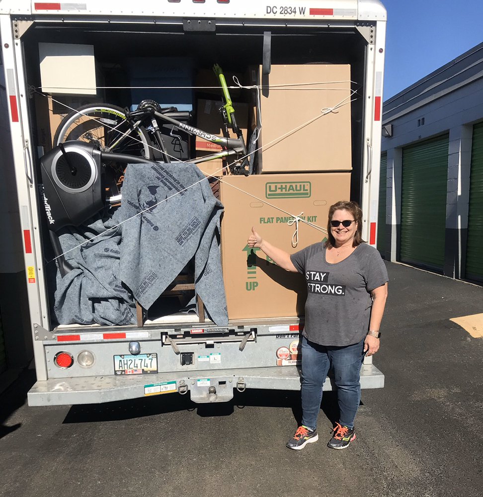 A happy customer giving a thumbs up beside a fully loaded truck
